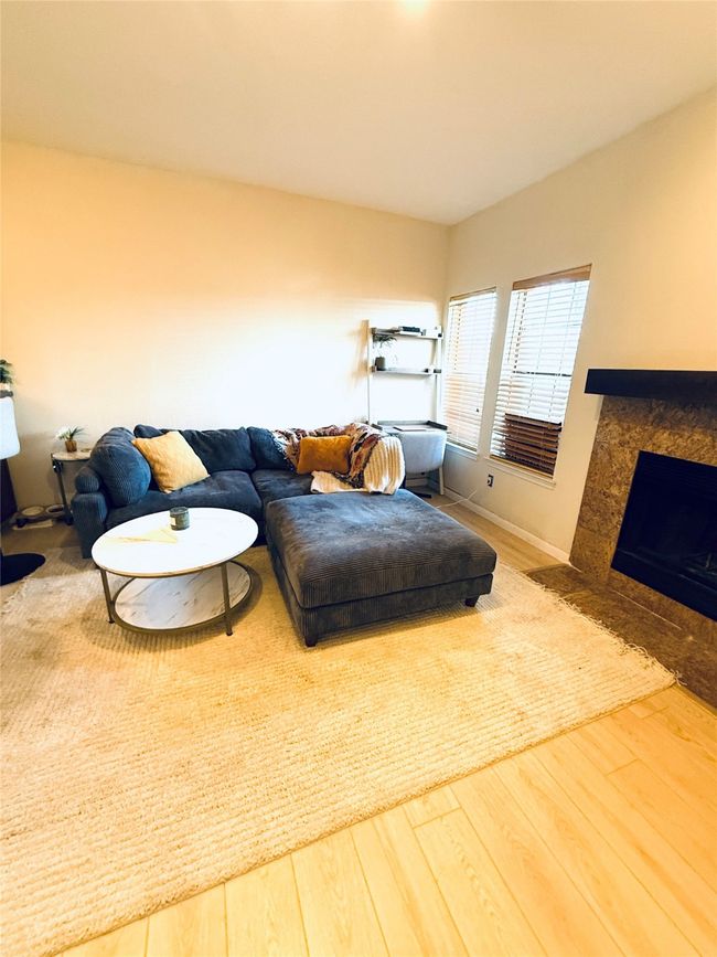 Living area with a high end fireplace and wood finished floors | Image 5