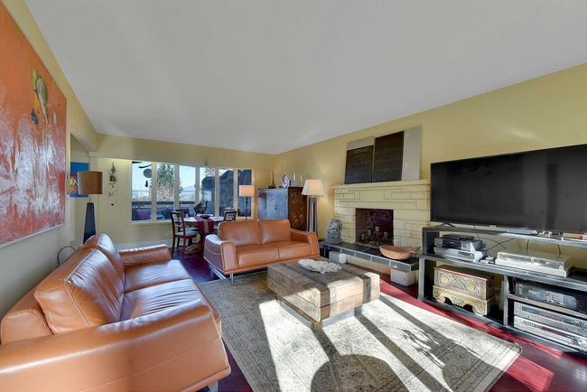 Living room with wood finished floors and a fireplace | Image 7