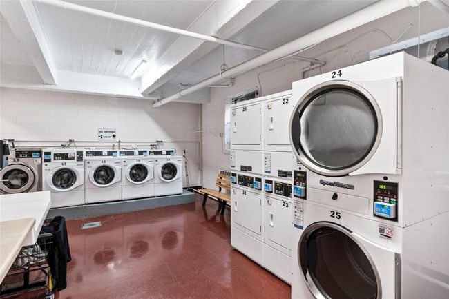 Community laundry featuring stacked washer / drying machine, independent washer and dryer, and concrete block wall | Image 14