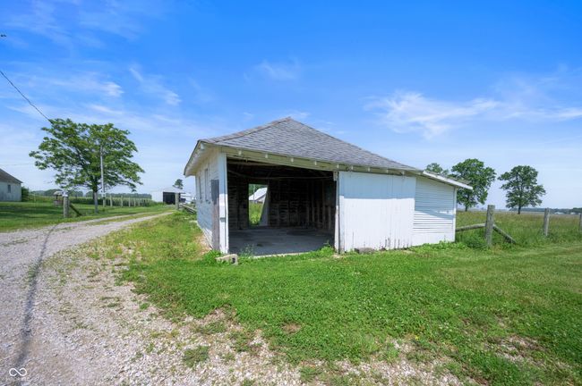 view of home's exterior featuring an outbuilding, a shingled roof, and dirt driveway | Image 19