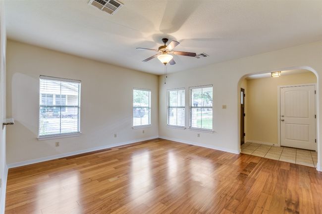 Spare room with arched walkways, a ceiling fan, and light wood-type flooring | Image 4