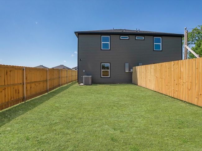 Rear view of property with central air condition unit, a lawn, and a fenced backyard | Image 25