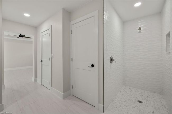 Bathroom with tiled shower, tile patterned floors, and ceiling fan | Image 27