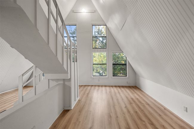 Additional living space featuring light laminate floors and high vaulted ceiling | Image 24