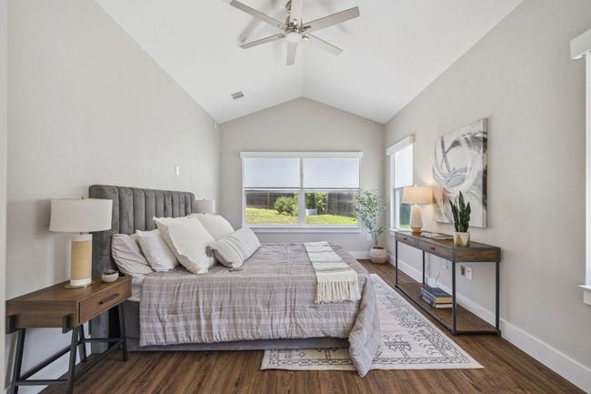 Bedroom with vaulted ceiling, wood finished floors, and ceiling fan | Image 21