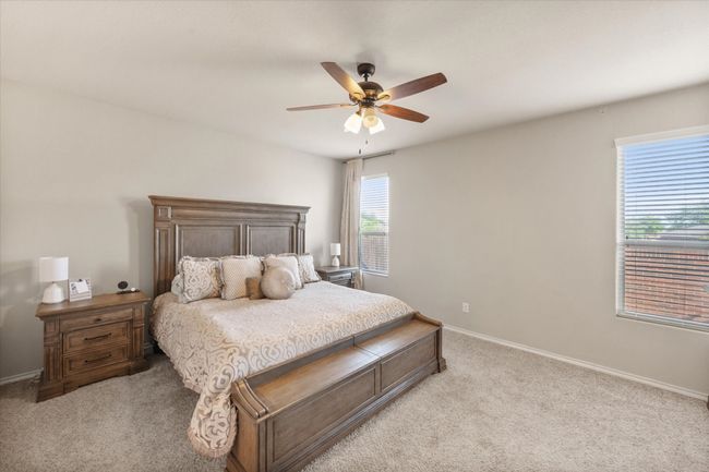 Bedroom featuring light colored carpet, baseboards, and ceiling fan | Image 25