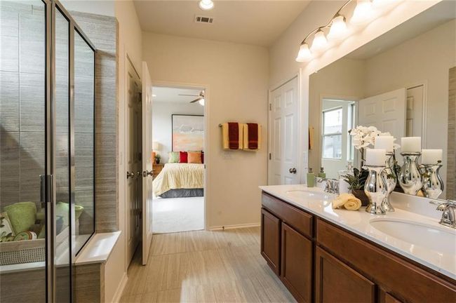 Full bathroom featuring ensuite bathroom, double vanity, a shower stall, and a ceiling fan | Image 21