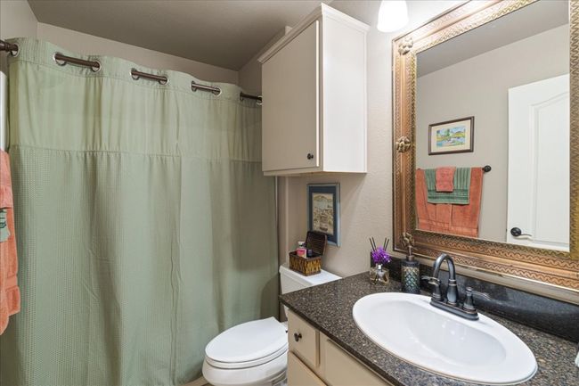 Bathroom featuring toilet, vanity, and a shower with shower curtain | Image 32