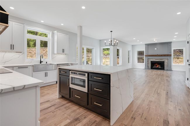 Kitchen featuring light wood-style flooring, decorative light fixtures, and a kitchen island | Image 9
