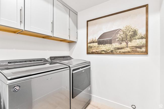 Laundry area with baseboards, cabinet space, and washer and clothes dryer | Image 44