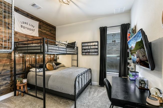 Carpeted bedroom with wood walls, baseboards, and visible vents | Image 24