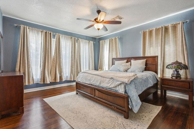 Bedroom with a textured ceiling, wood finished floors, and a ceiling fan | Image 21