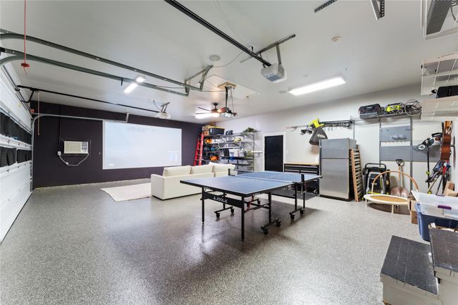 The epoxy-coated, air-conditioned and heated 3-car garage provides versatile space | Image 21