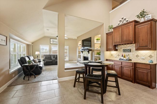 Kitchen featuring baseboards, lofted ceiling, open floor plan, and decorative backsplash | Image 18