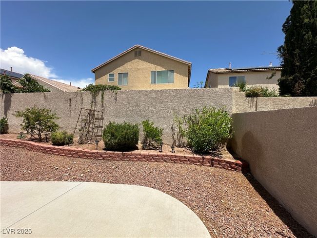 View of property exterior featuring a fenced backyard, stucco siding, and a patio | Image 28
