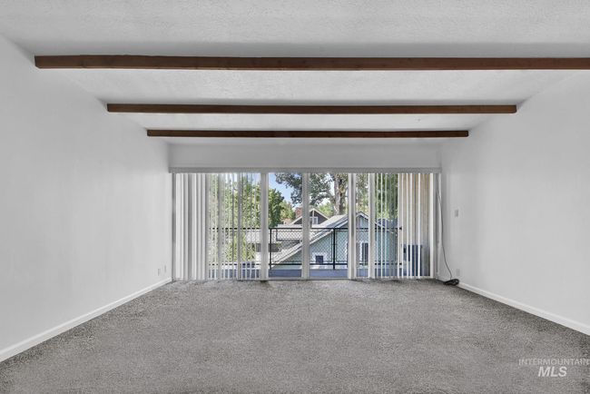 Carpeted spare room with beamed ceiling | Image 9