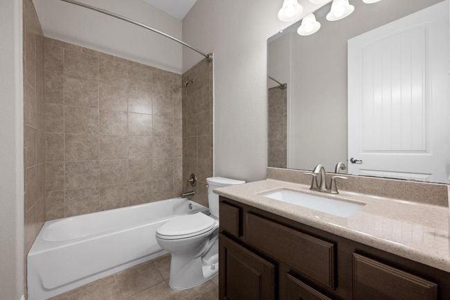 Bathroom with vanity, washtub / shower combination, and tile patterned floors | Image 21
