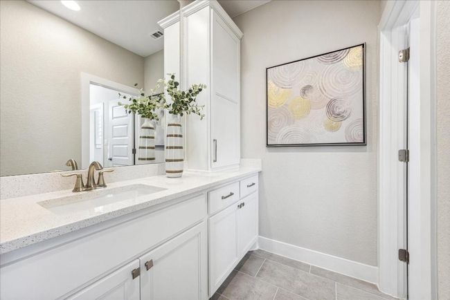 Two of the upstairs bedrooms have their own vanity with a connected bath. | Image 29