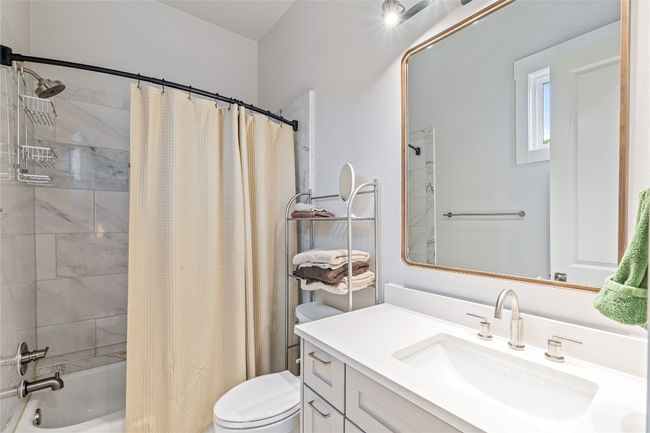 Bathroom with toilet, shower / bath combo with shower curtain, and vanity | Image 27