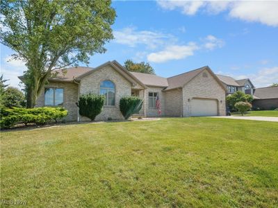 Ranch-style home with a front lawn and a garage | Image 1