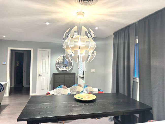 Dining room with wood finished floors and a chandelier | Image 6