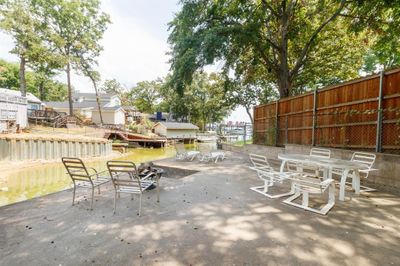 View of outdoor concrete patio by the water. | Image 3