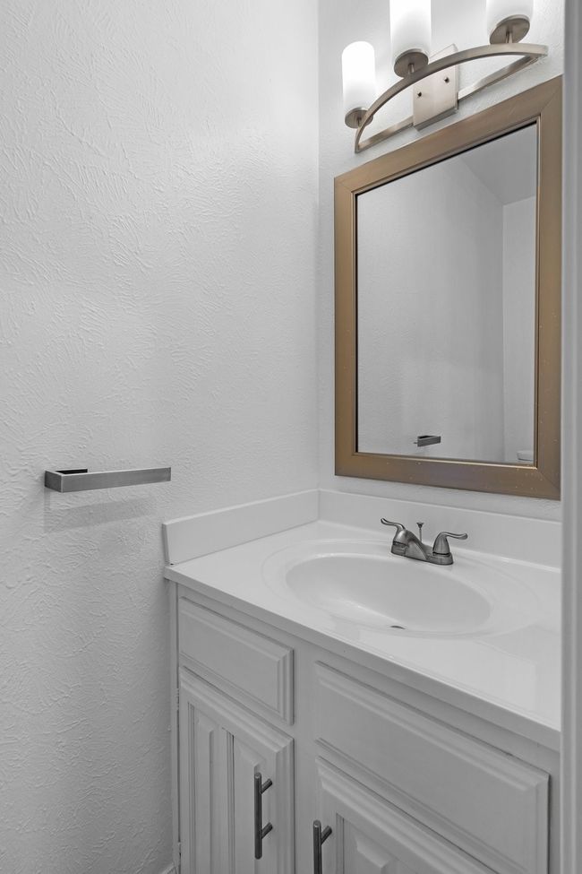 Bathroom with a textured wall and vanity | Image 26