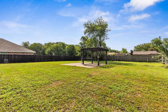 Fenced backyard with a pergola and a patio area | Image 13