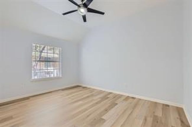 Spare room featuring wood finished floors, a ceiling fan, and vaulted ceiling | Image 19