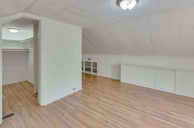 Additional living space with light wood-style flooring and vaulted ceiling | Image 15