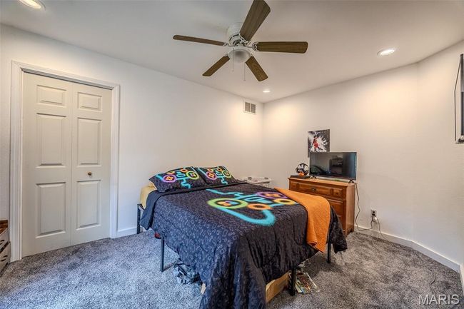 Bedroom with carpet flooring, ceiling fan, and recessed lighting | Image 38
