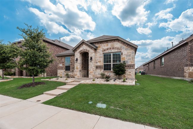French provincial home with a front yard, stone siding, a shingled roof, and central AC | Image 5