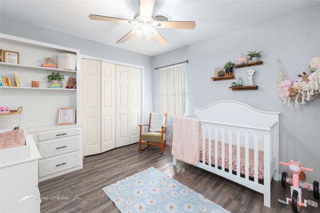 Bedroom with a nursery area, a ceiling fan, wood finished floors, and a closet | Image 24