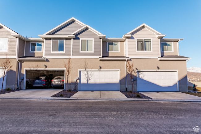 View of property featuring concrete driveway, a garage, and stucco siding | Image 20