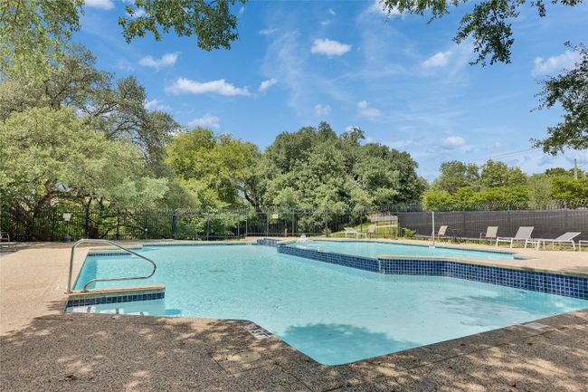 Community pool featuring view of wooded area and a patio | Image 30