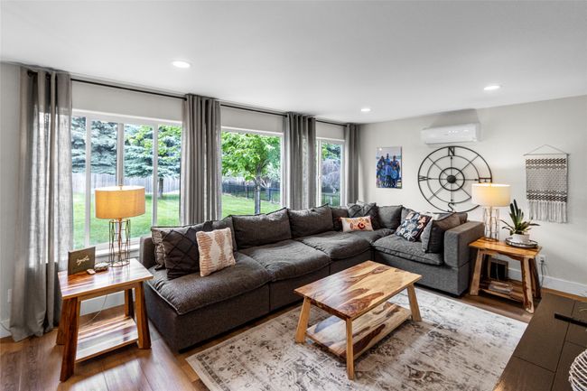 Living room with wood finished floors, a wall unit AC, and recessed lighting | Image 28