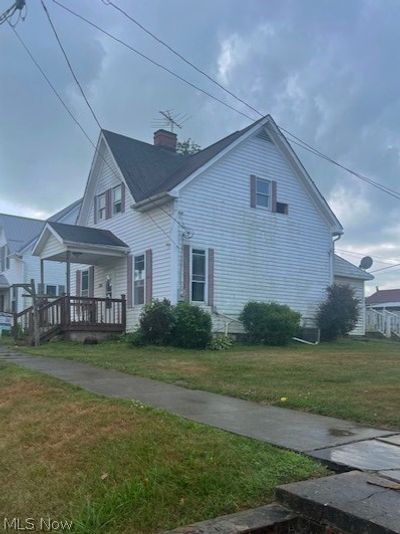 View of side of home with a porch and a yard | Image 3