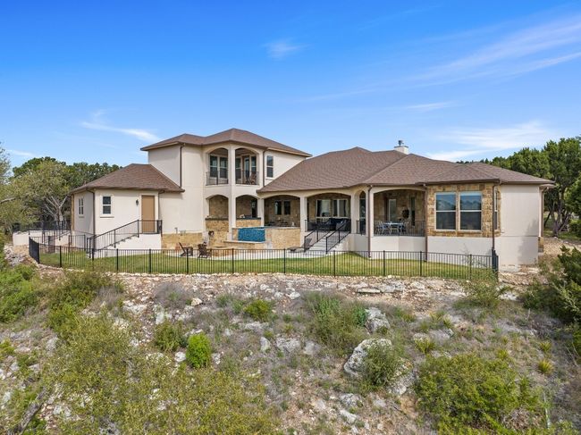 Back of property with stone siding, a patio area, a fenced backyard, and stucco siding | Image 37