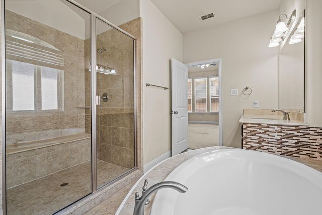 Bathroom with a shower stall, a bath, and vanity | Image 19
