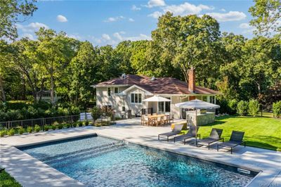 Back of house with a patio, a yard, and a fenced in pool | Image 1