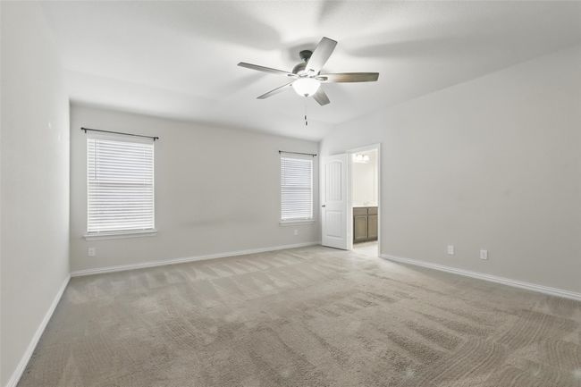 Spare room with a ceiling fan, light carpet, and baseboards | Image 14