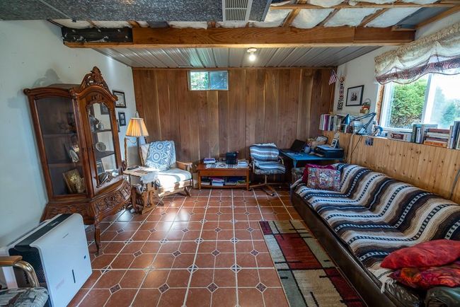 Living room featuring wood walls and a healthy amount of sunlight | Image 25
