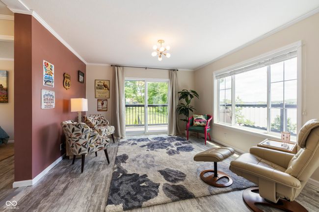 sitting room featuring wood finished floors, ornamental molding, baseboards, and a chandelier | Image 9