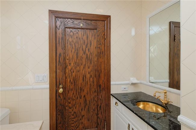 Hall bath also adjacent to bedroom 2, granite topped storage vanity, ceramic tile surround, full tub | Image 22