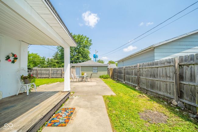 Large fenced backyard featuring a patio area and a wooden deck | Image 31