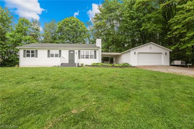 View of front of property featuring a garage and a front lawn | Image 1