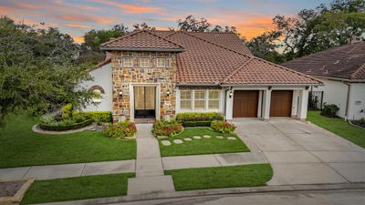 Reminiscent of old world charm, this gorgeous Darling Home situated on an oversized wooded corner lot features a stucco exterior with stone & brick accents surrounded by professional landscaping including stone-lined flower beds serviced by an automatic sprinkler system. The double-wide driveway leads to the home's 3-car attached garage illuminated by coach lantern lighting accentuated by wood-stained overhead doors and decorative corbels. Included is a whole home generator! | Image 1