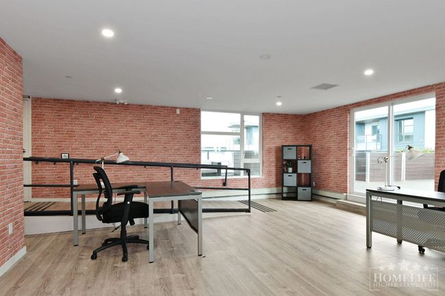 Office area with brick wall, baseboards, wood finished floors, and recessed lighting | Image 29