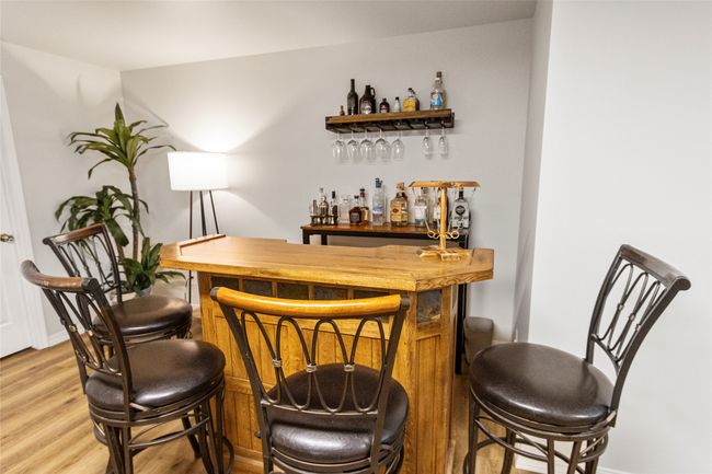 Indoor dry bar featuring light wood-style flooring and baseboards | Image 37