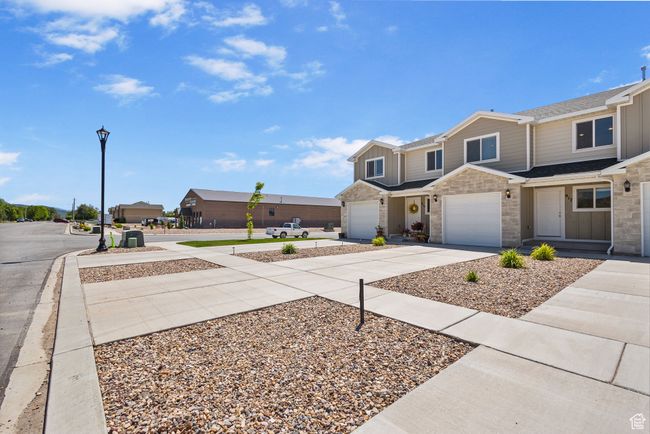 View of property with concrete driveway, a garage, and a shingled roof | Image 4